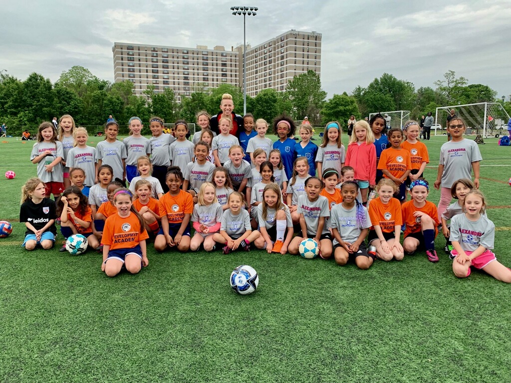 Junior Academy girls pose with Joanna Lohman after practice